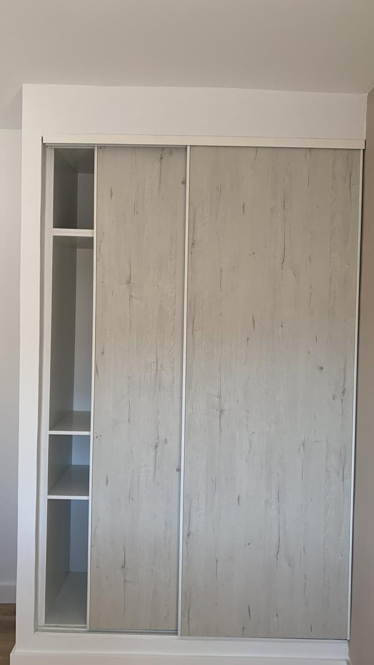 Armario empotrado con puertas correderas de madera por AARSTEK