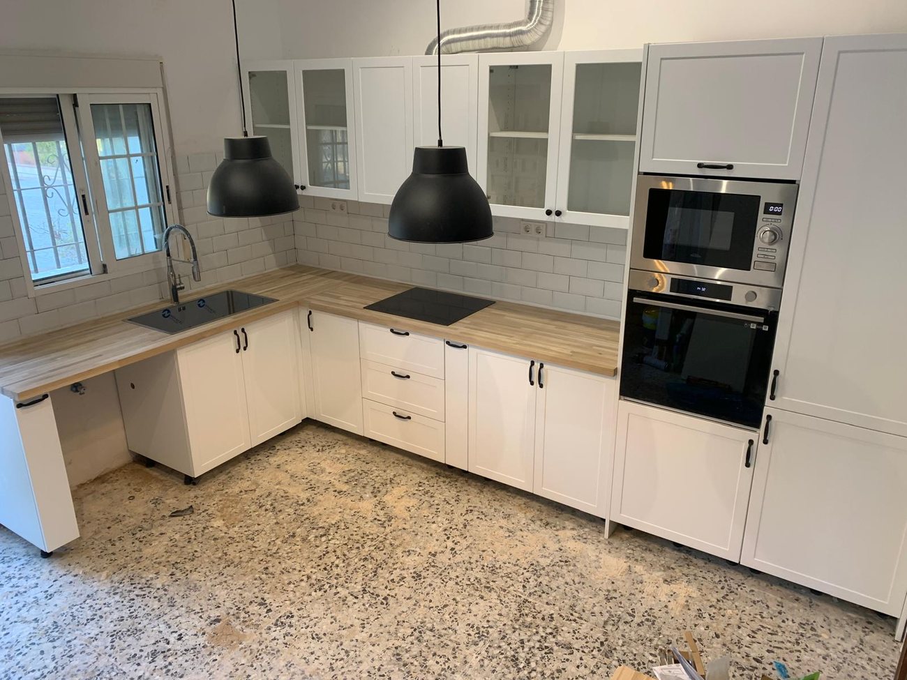 Cocina en blanco con encimera de madera por AARSTEK